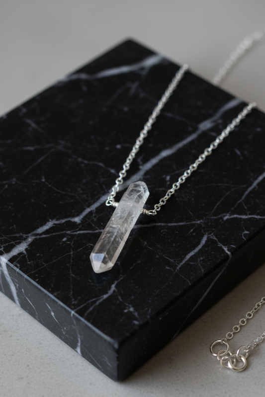 Crystal pendant necklace on a black marble surface