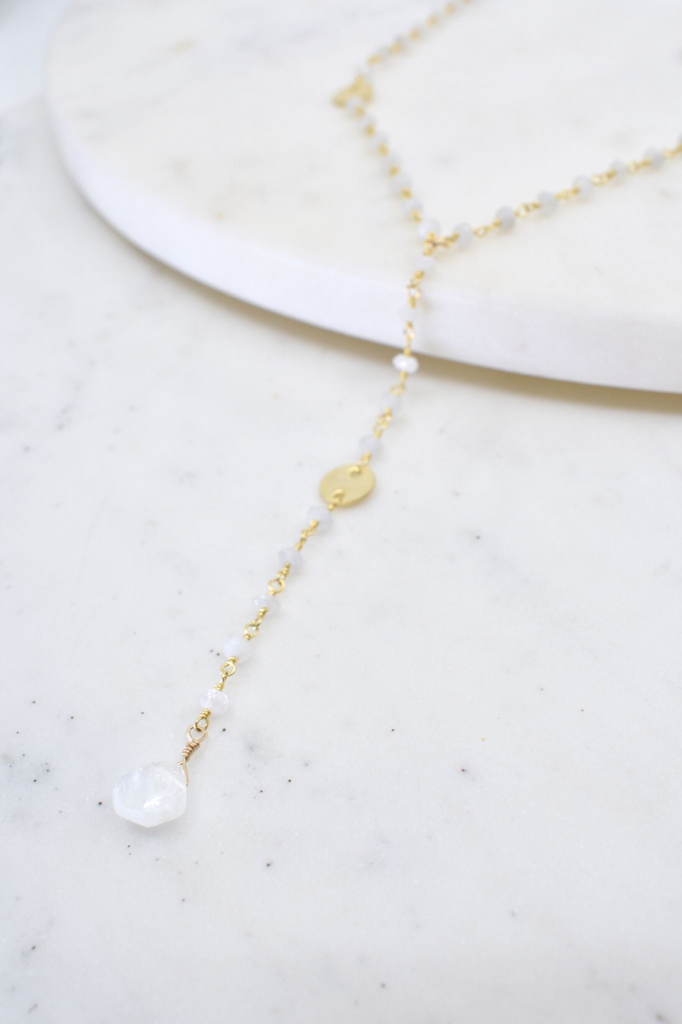 Delicate gold and pearl necklace on a marble surface