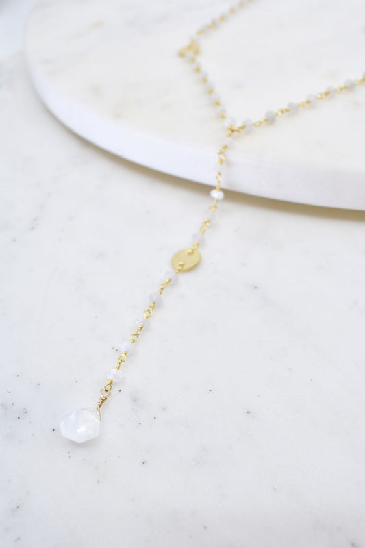 Delicate gold and pearl necklace on a marble surface