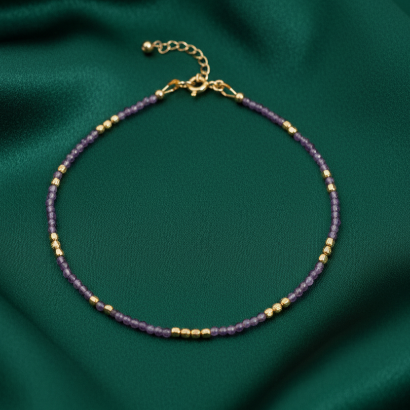 Anklet against green silky backdrop.