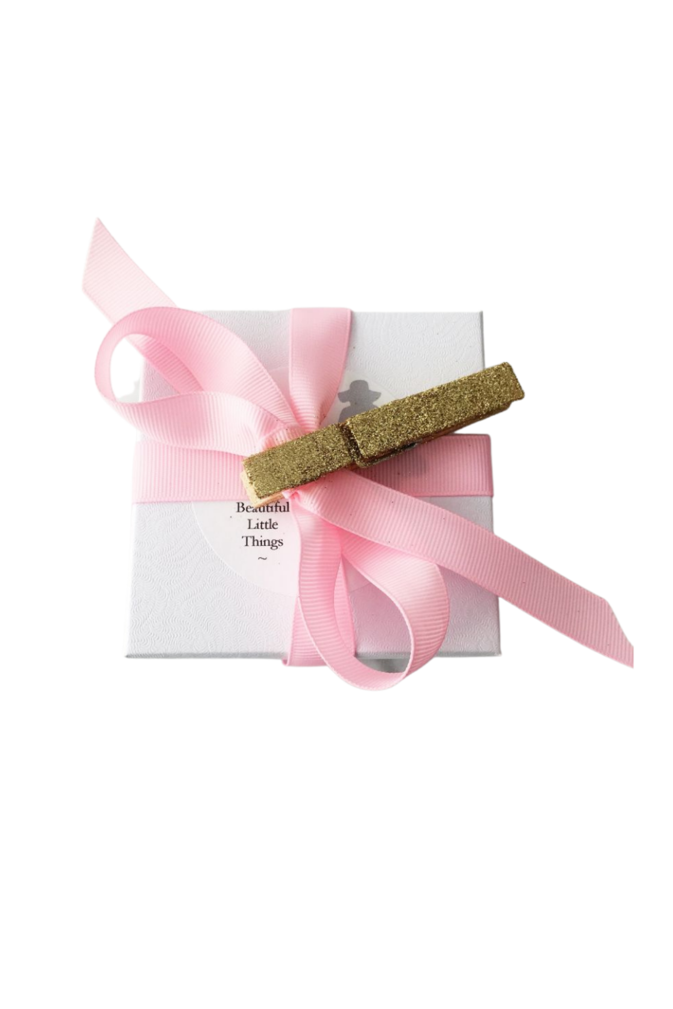 Glittery hair clip on a pink ribbon with a white box labeled 'Beautiful Little Things' on a white background