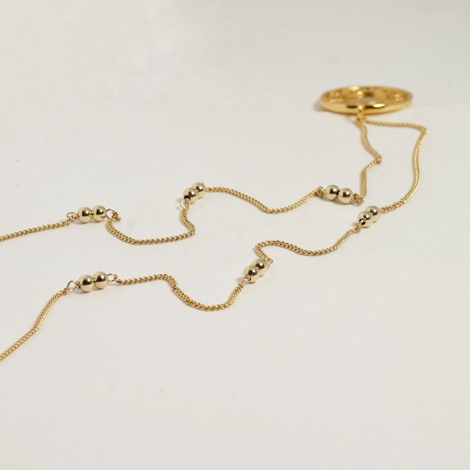 Gold necklace on a light gray background