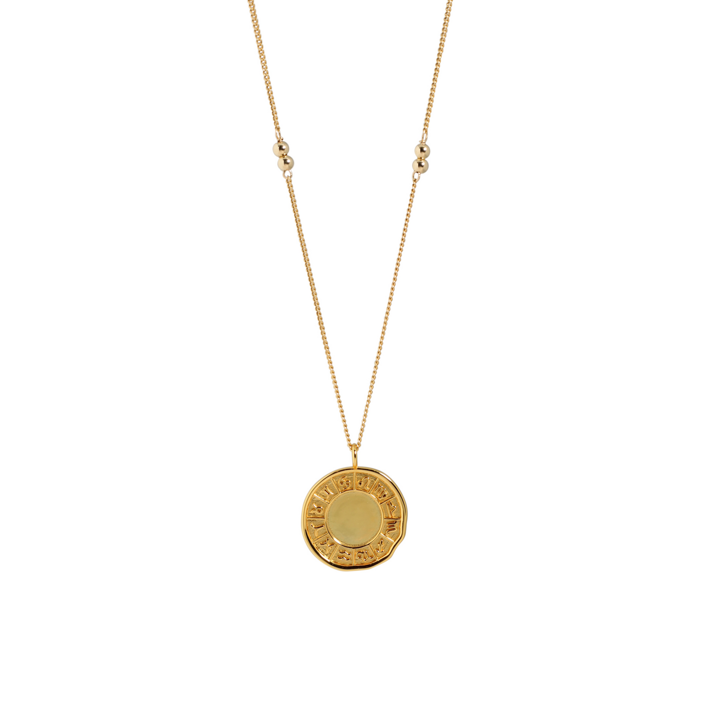 Gold necklace with a round pendant on a white background
