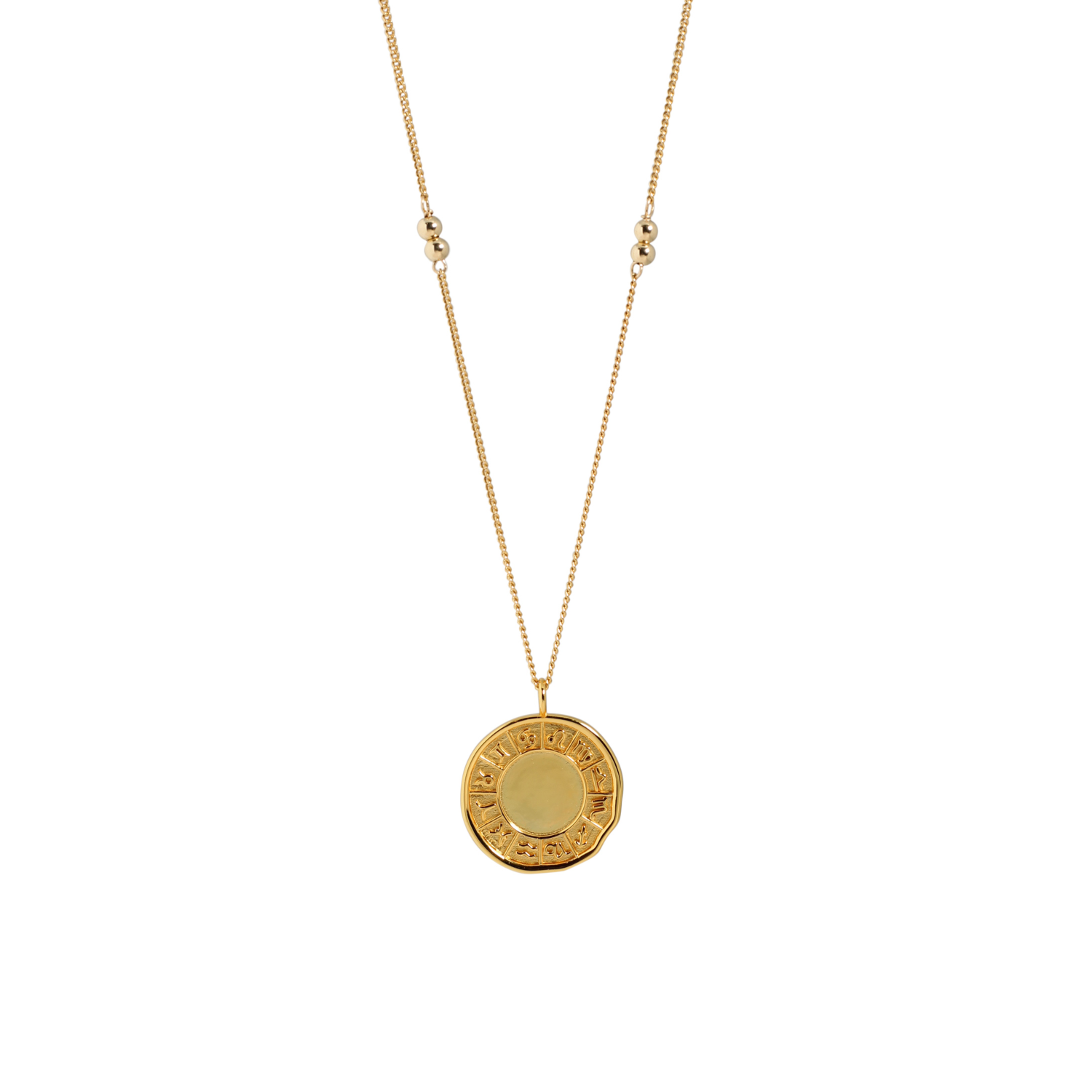 Gold necklace with a round pendant on a white background